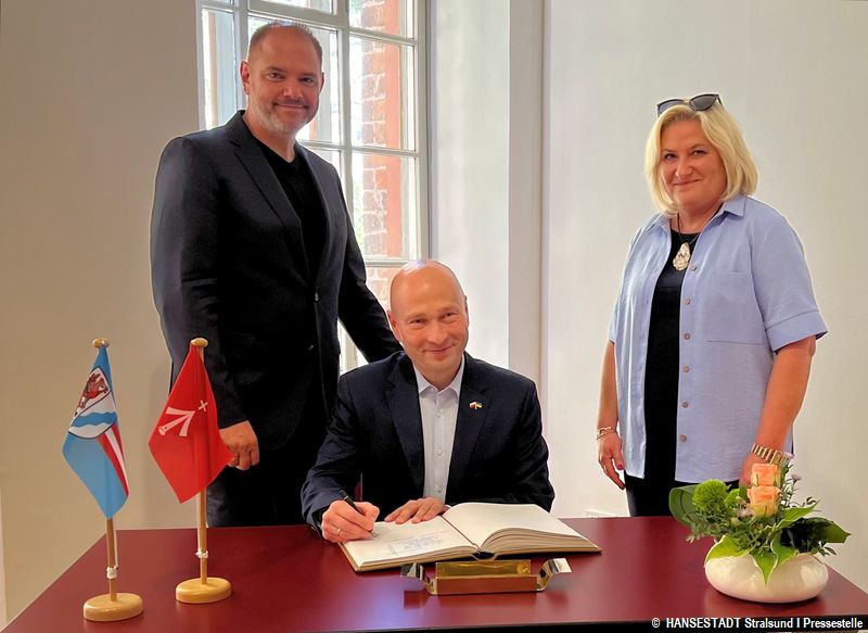 Rafal Zając, Bürgermeister der Partnerstadt Stargard und Ewa Sowa, stellv. Bürgermeisterin Partnerstadt Stargard beim Eintrag ins Gästebuch der Hansestadt Stralsund gemeinsam mit Oberbürgermeister Alexander Badrow